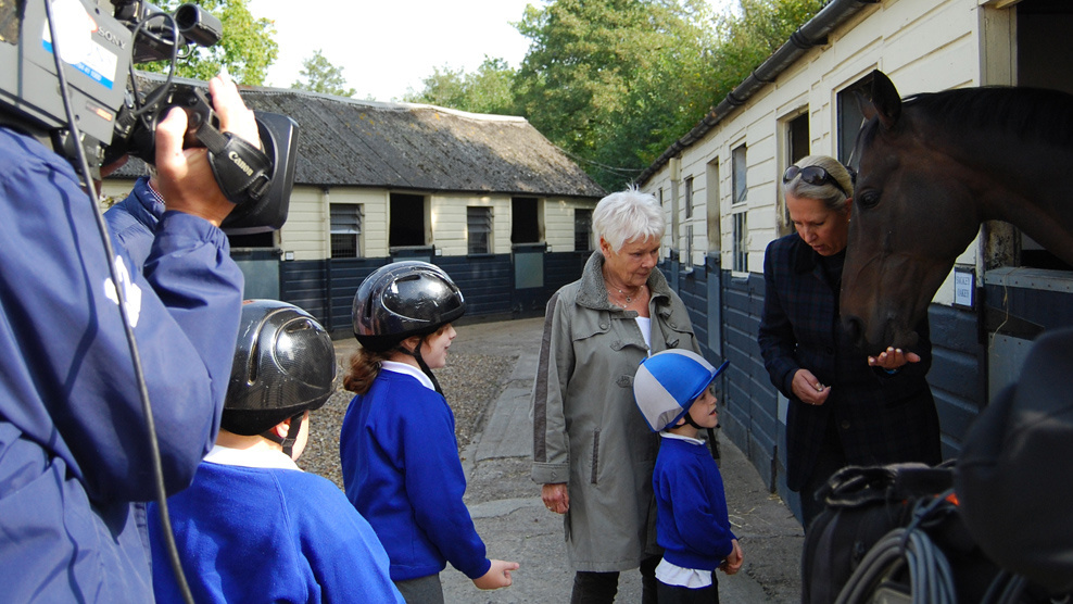 Dame Judi Dench talks to RDA children from Queen Elizabeth II School, Horsham and her...