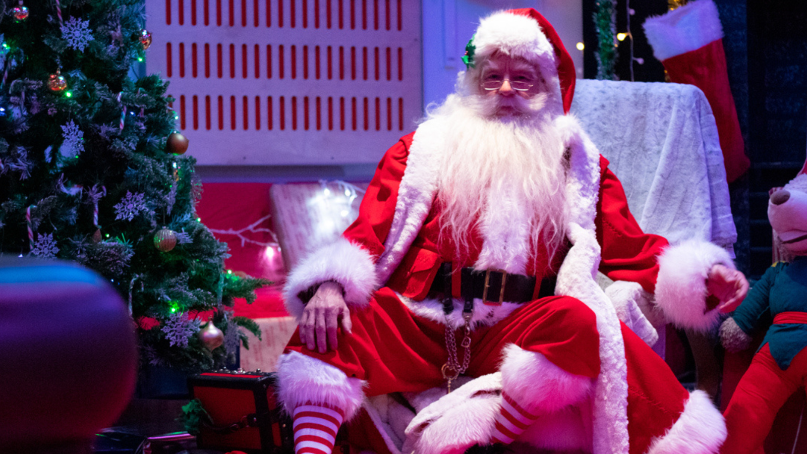 Father Christmas sat in his Grotto at The Point, surrounded by a Christmas tree, toys and presents