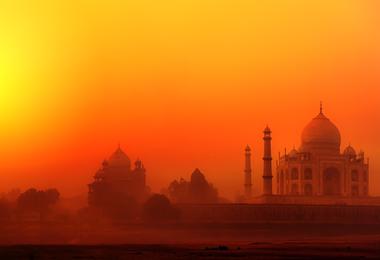 A view over the water to the Taj Mahal in Agra at sunset