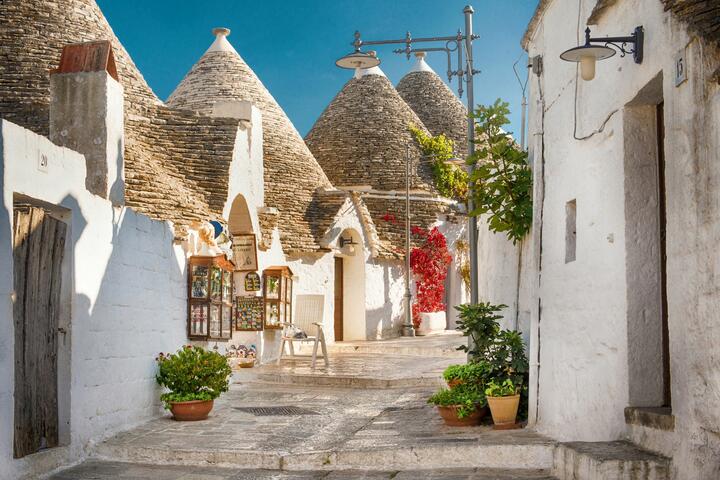 white buildings with conical roofs with Alberobello in the background