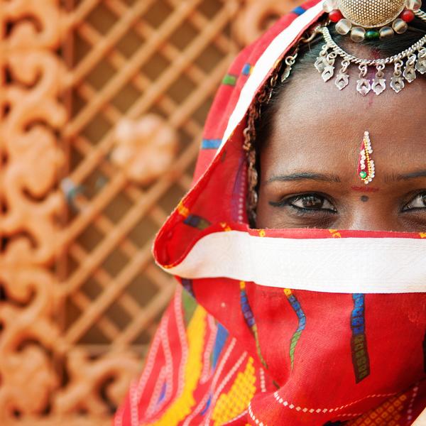Traditional Indian woman in sari costume covered her face with veil, India