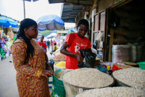 A woman bargains for the price of food with a store keeper at a grain shop in Garki market Abuja