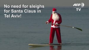 Santa-Claus-floats-to-Tel-Aviv-on-his-standup-paddleboard
