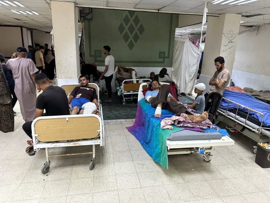 Wounded Palestinians, who were injured in an Israeli strike, lie on beds as Gaza’s overwhelmed Al-Aqsa hospital struggles to treat the wounded, amid the Israel-Hamas conflict, in Deir Al-Balah