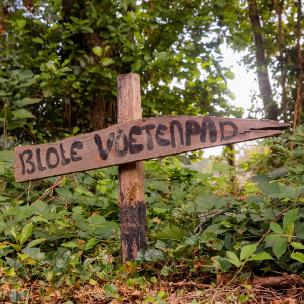 Houten bordje met de tekst blote voetenpad