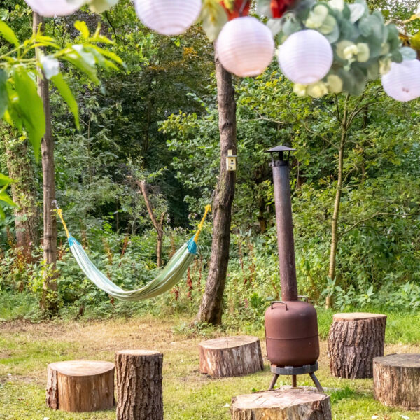 Buitenkachel met houten stronken als stoeltjes