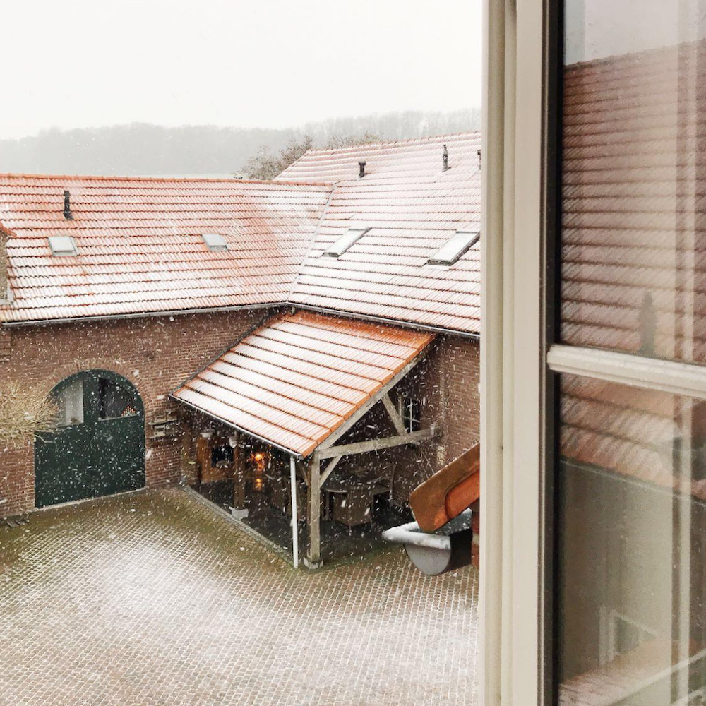 Doorkijkje vanuit het raam op witte daken
