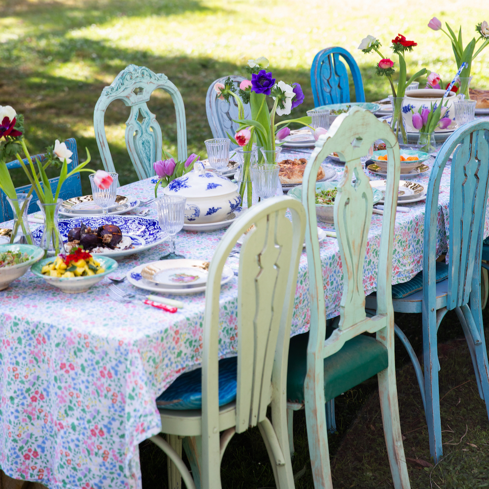 Gedekte tafel in het gras, met stoelen in kleuren blauw