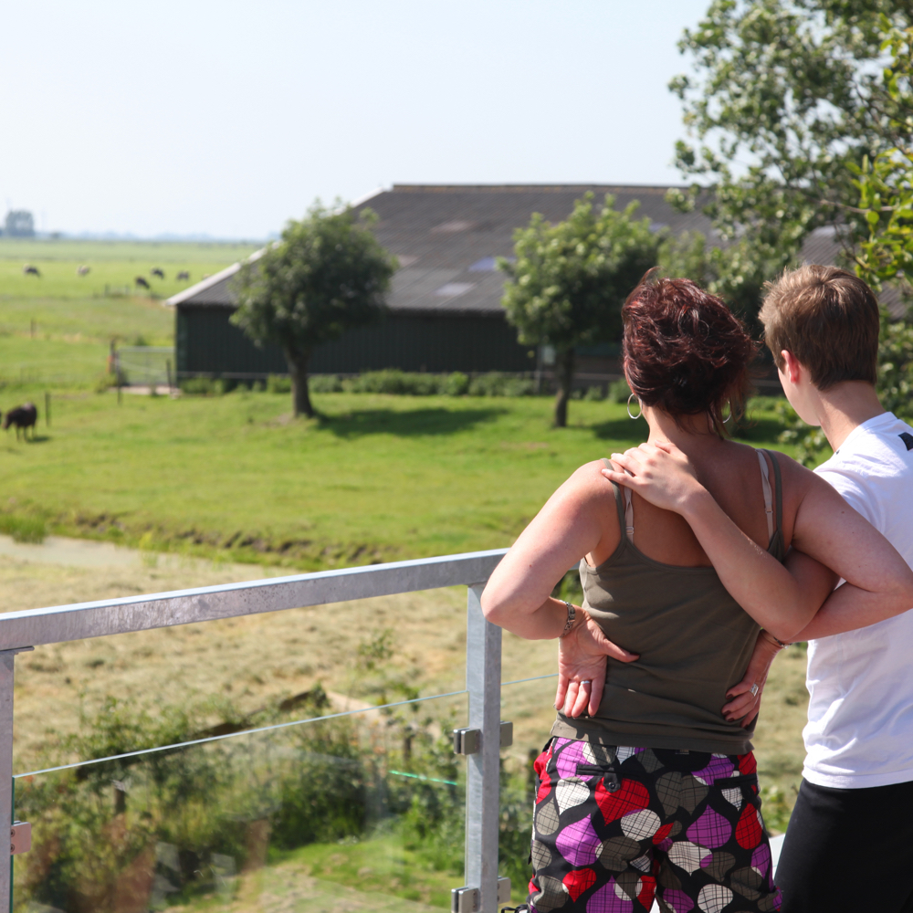 Een man en een vrouw kijken naar een boerderij