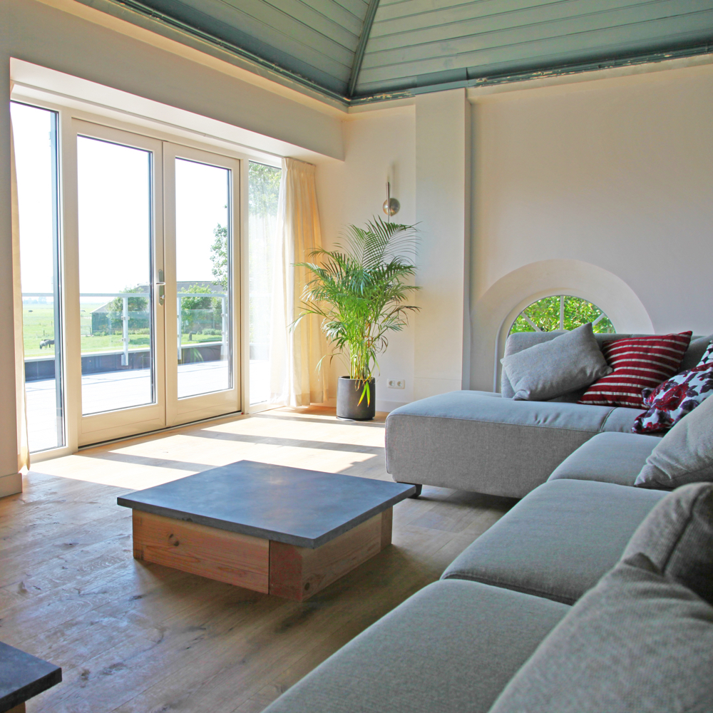 Comfortabele bank in de woonkamer, met een uitzicht op weides