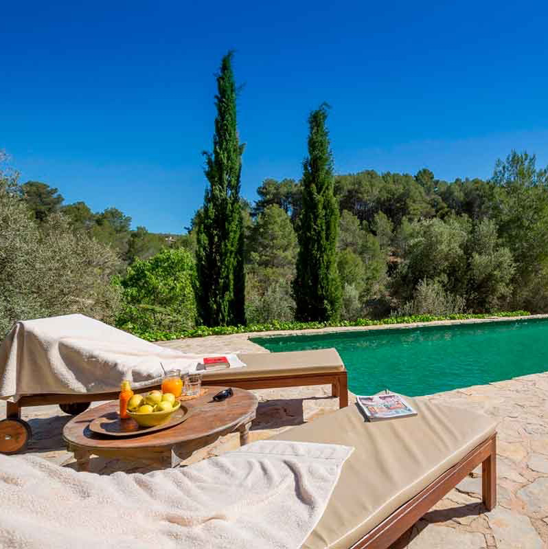 Ligbedden met fruit en sapjes aan de rand van het zwembad