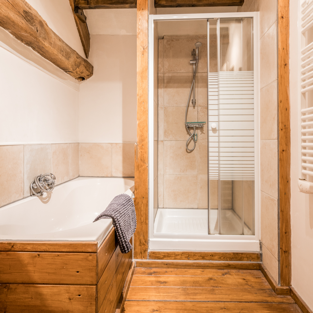 Badkamer met douche en ligbad
