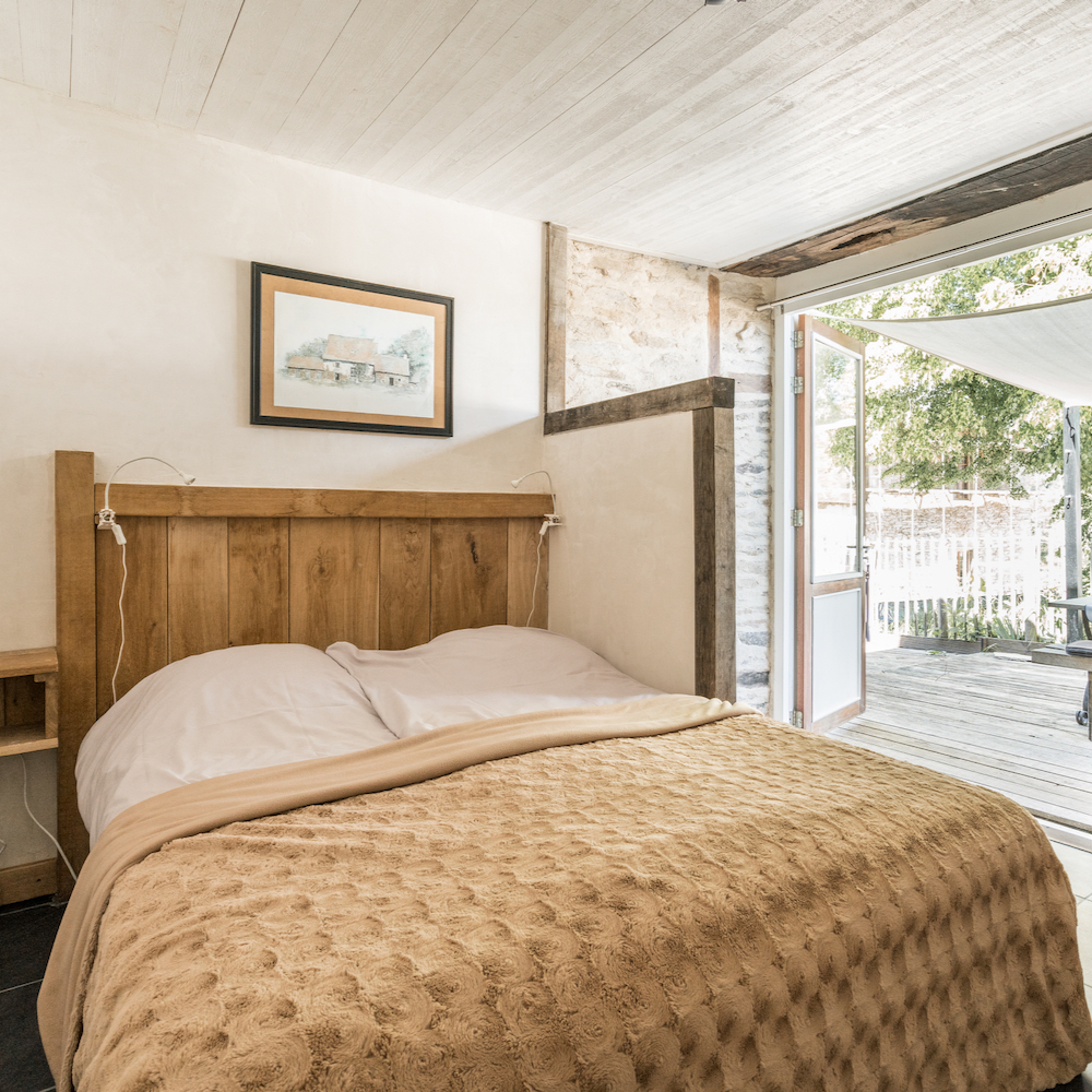 Bed voor de openslaande tuindeuren bij een van de vakantiehuizen
