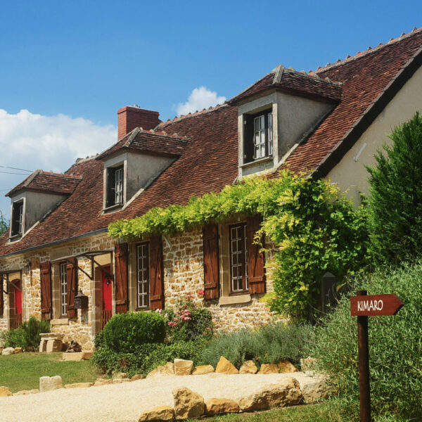 Een typisch Franse boerderij met luiken en een wegwijzer met de tekst Kimaro