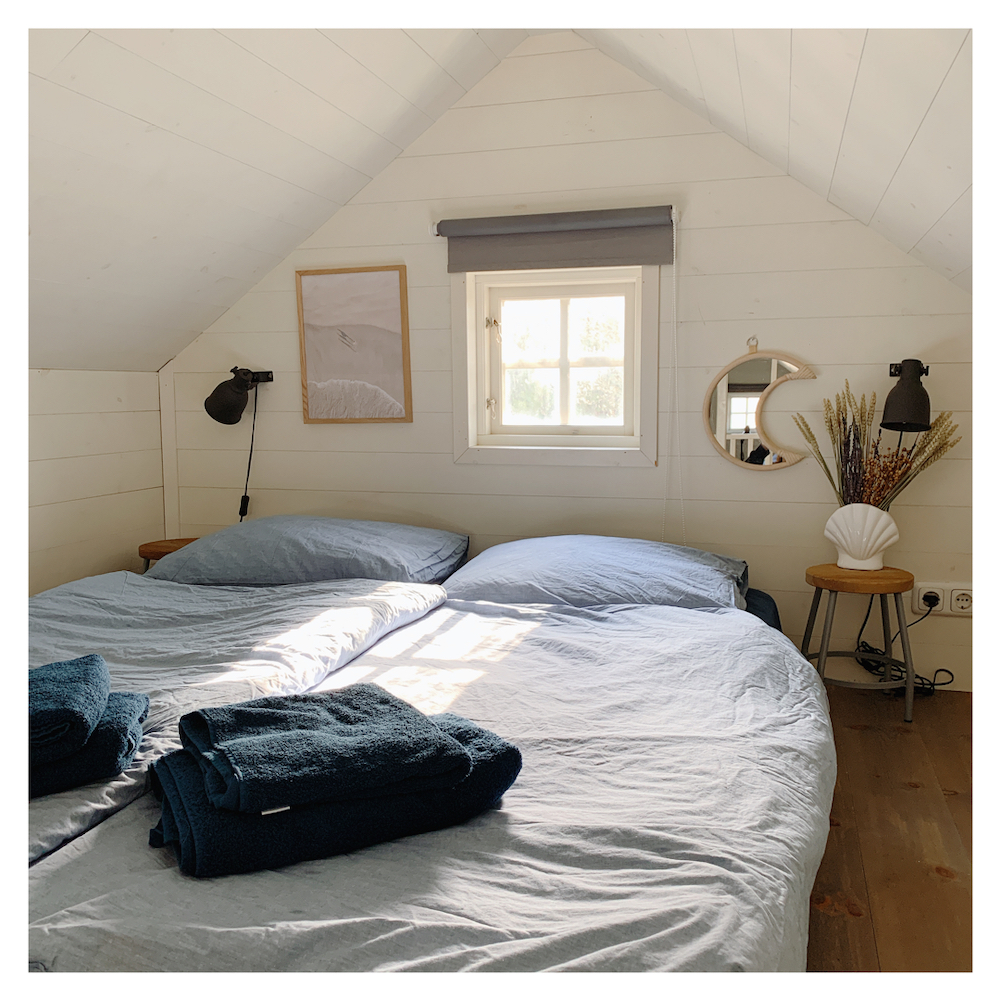 De slaapkamer op de vide heeft een tweepersoons bed met boxspring.