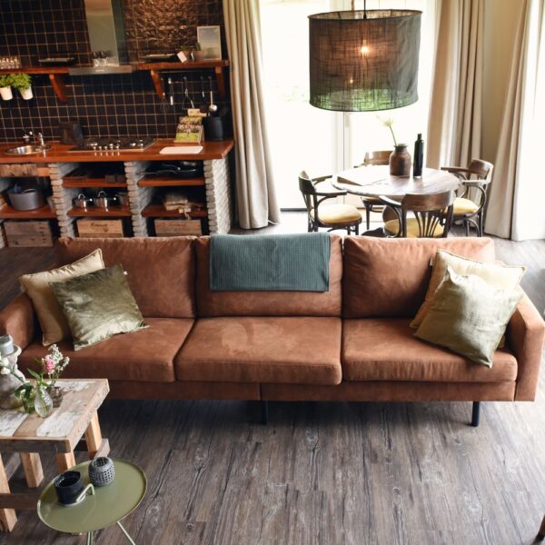 Woonkamer met bruine bank, een ronde eettafel