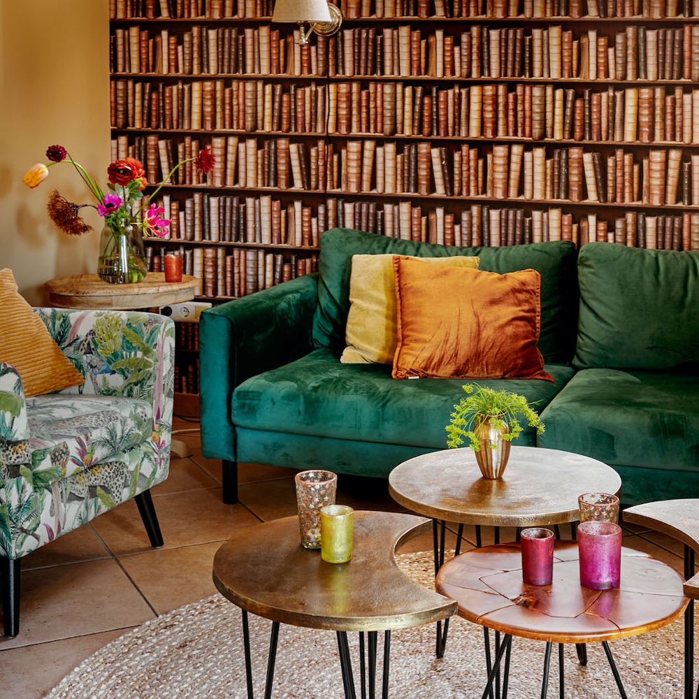 Zithoek met behang van een boekenkast