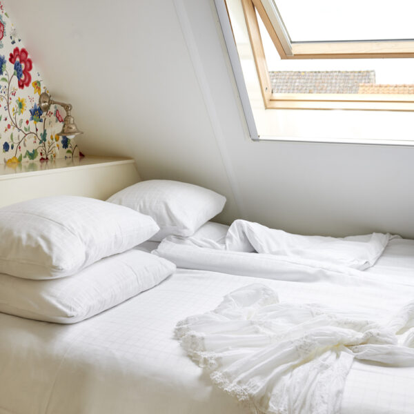Tweepersoons bed onder een dakraam