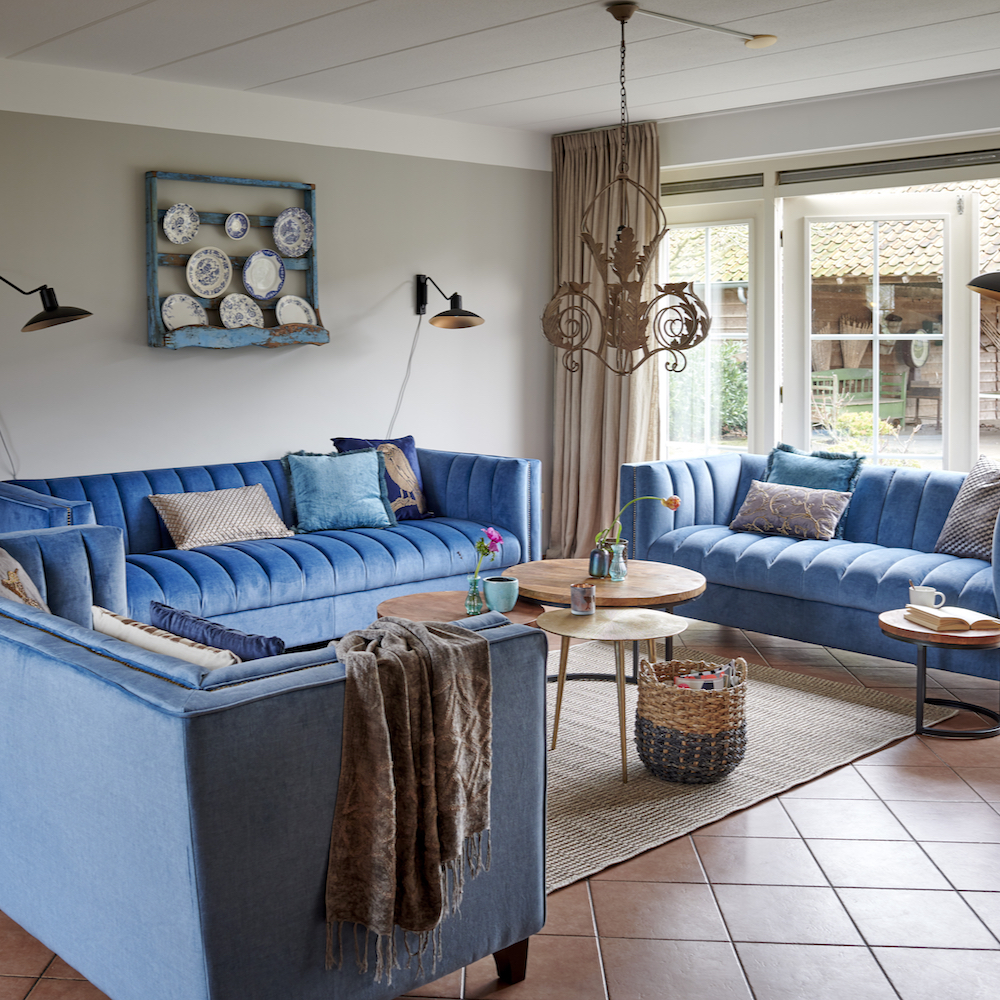 Woonkamer met blauwe banken en brocante accessoires