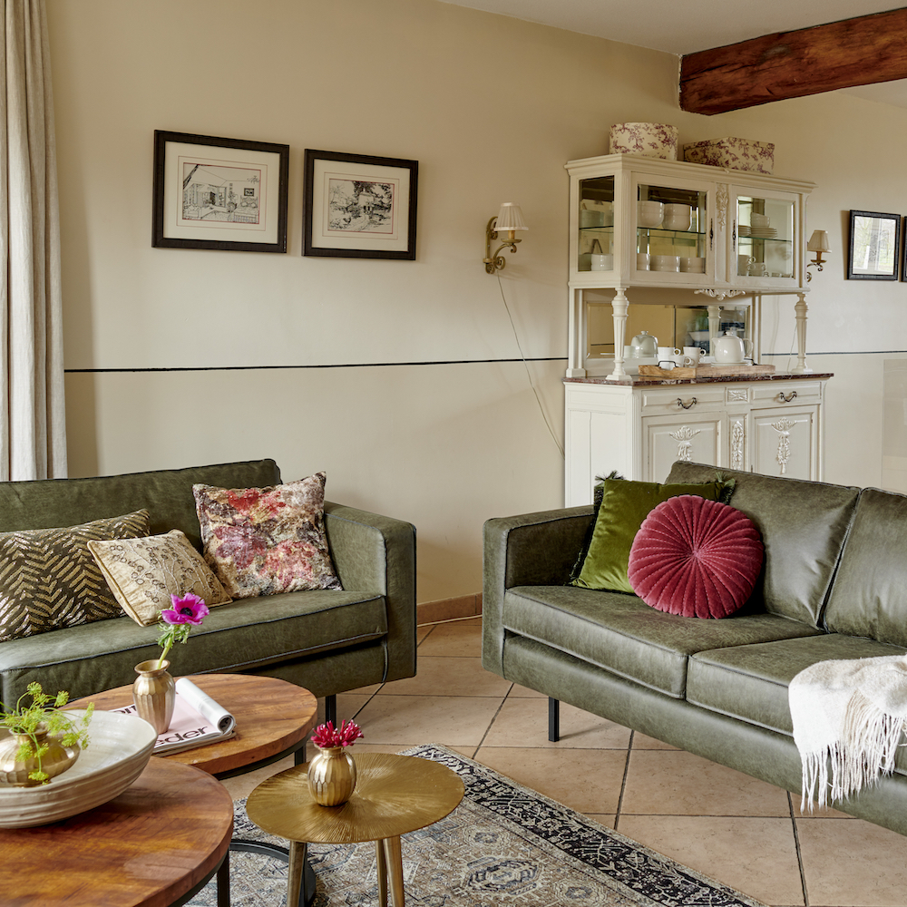 Detail woonkamer met twee legergroene banken