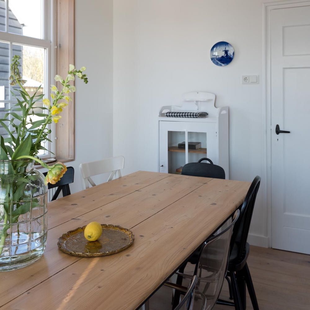 Eettafel met gele bloemen erop in het vakantiehuis in Domburg