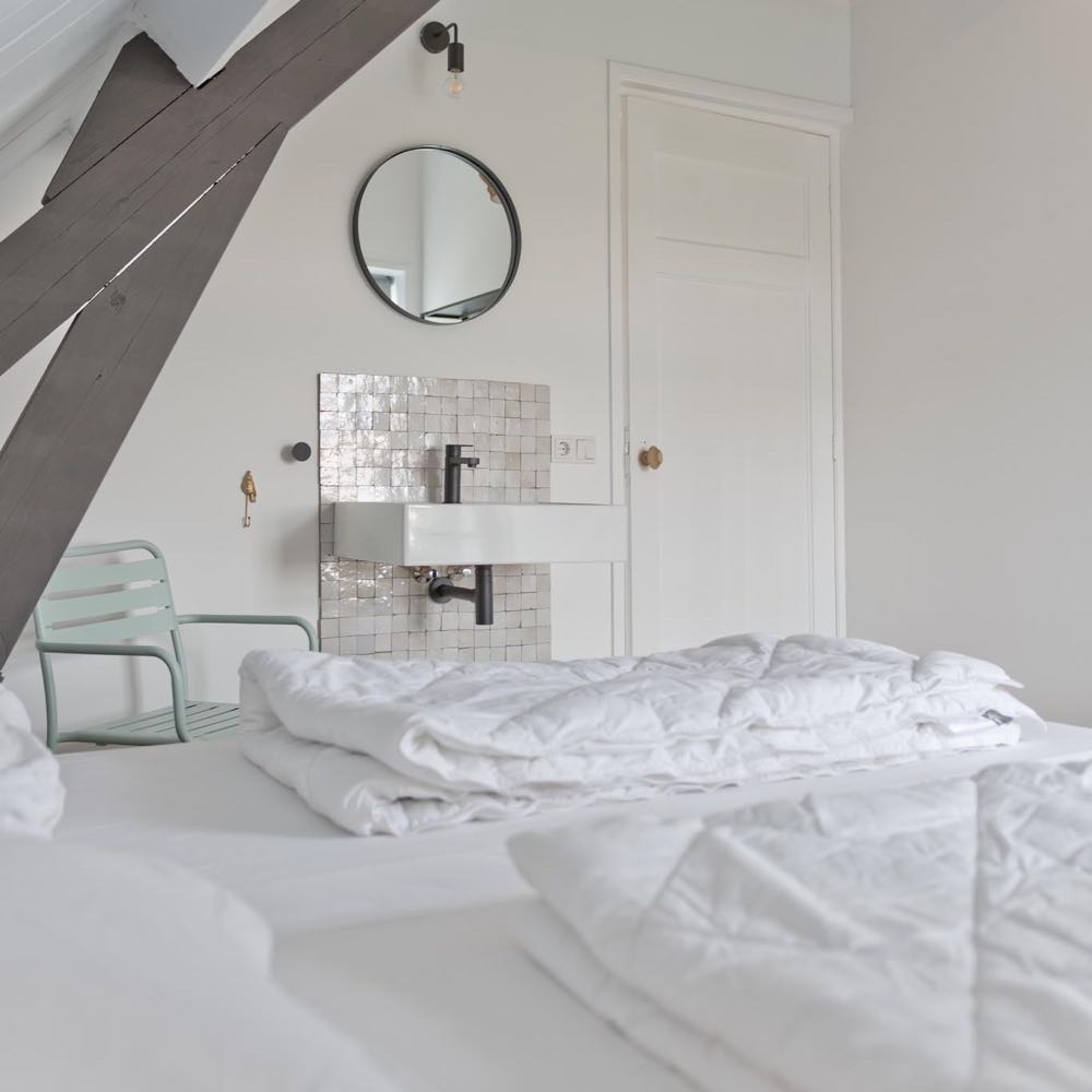 Dekbedden op bed in de slaapkamer van het vakantiehuis in Domburg