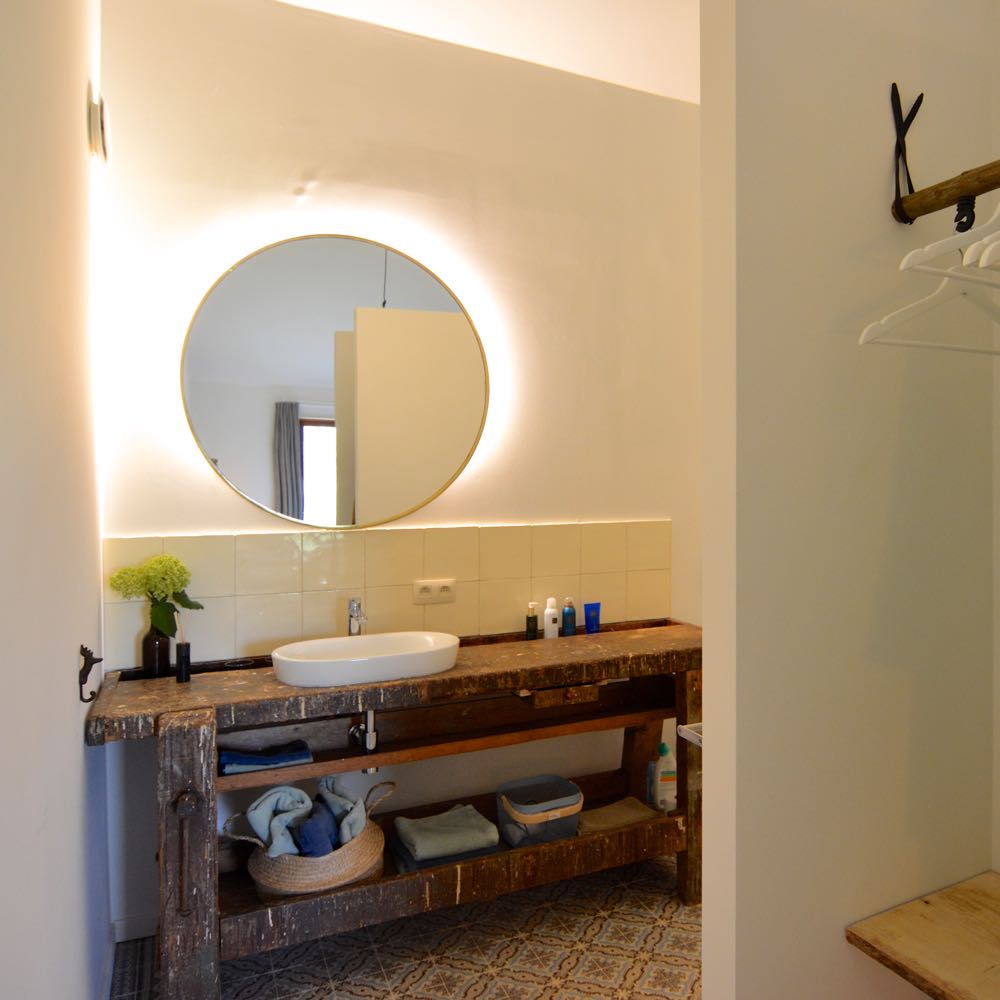 Open badkamer met oude werkbank als wastafel blad