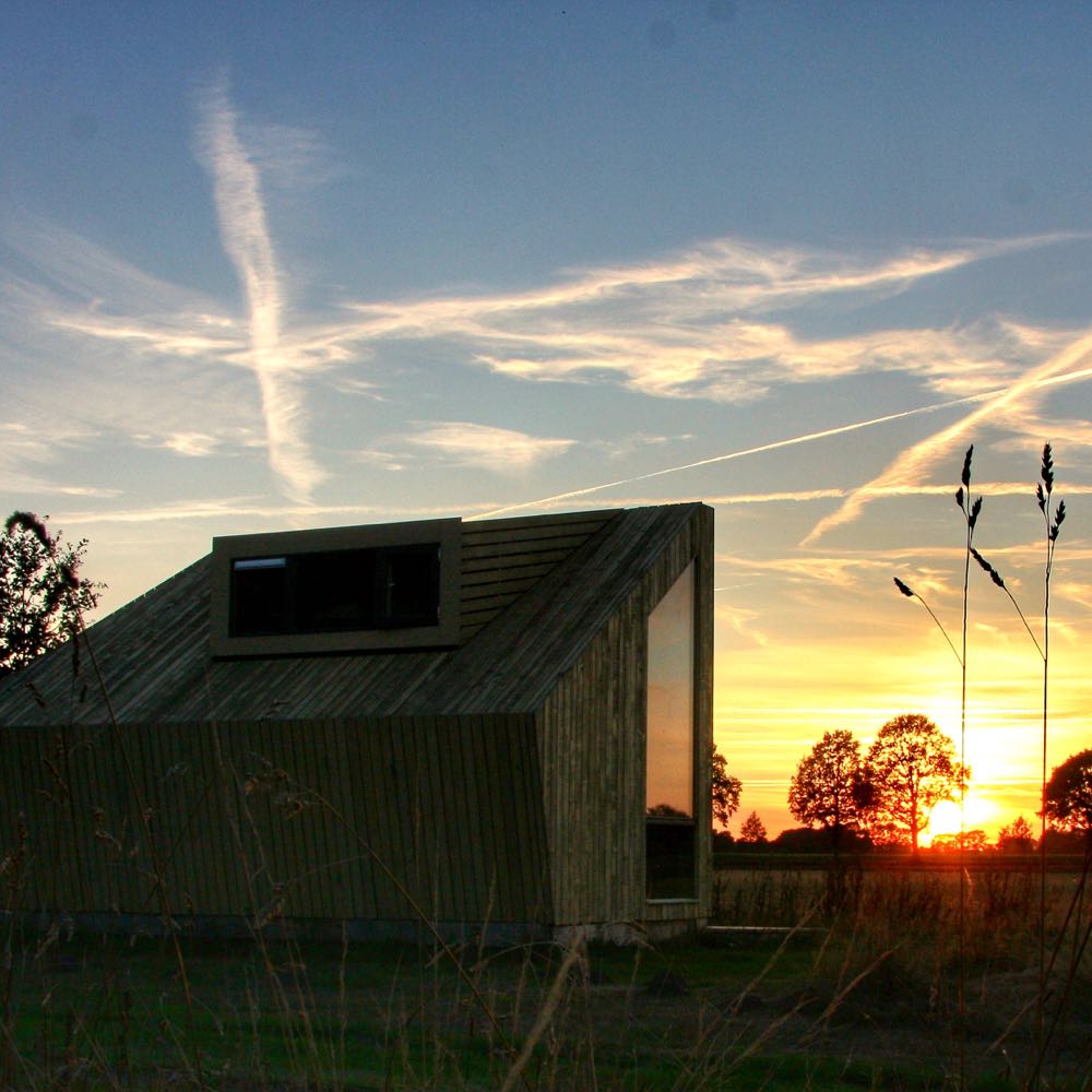 Houten tiny house bij zonsondergang