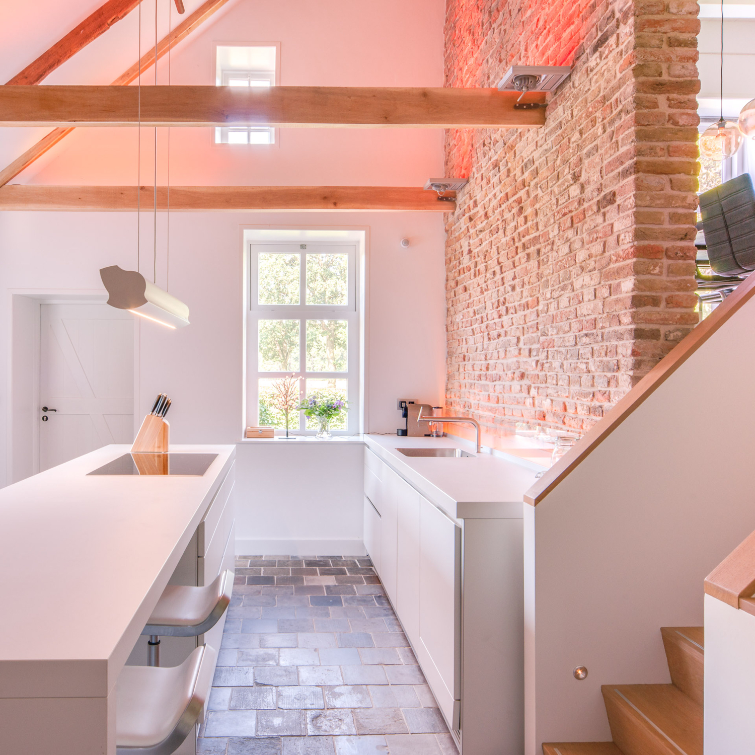 Strakke witte keuken met authentieke tegelvloer