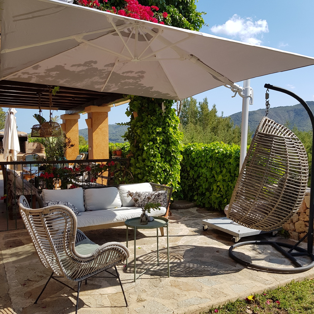 Loungestoelen en een hangstoel op een terras van een hotel op Ibiza