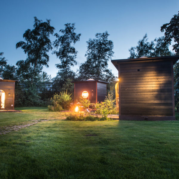 Een bijzonder adres voor je vakantie in Twente: slapen in een Sterrenkubus. Prachtig verlicht in de schemering.