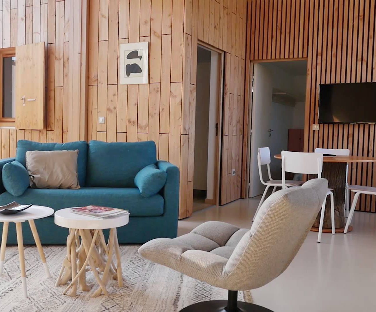 Woonkamer met fauteuil en blauwe bank van vakantiehuis