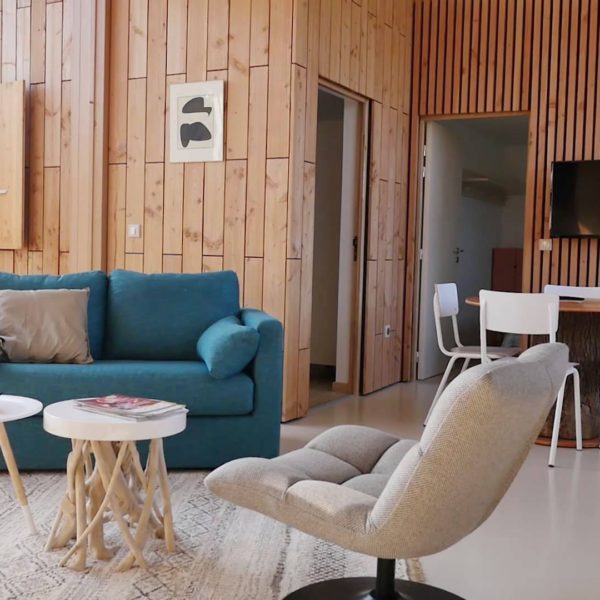 Woonkamer met fauteuil en blauwe bank van vakantiehuis