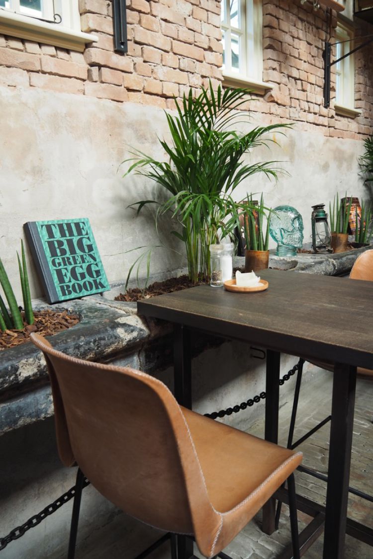 Hoge tafel en stoelen met aan zijkanten planten en borden met quotes