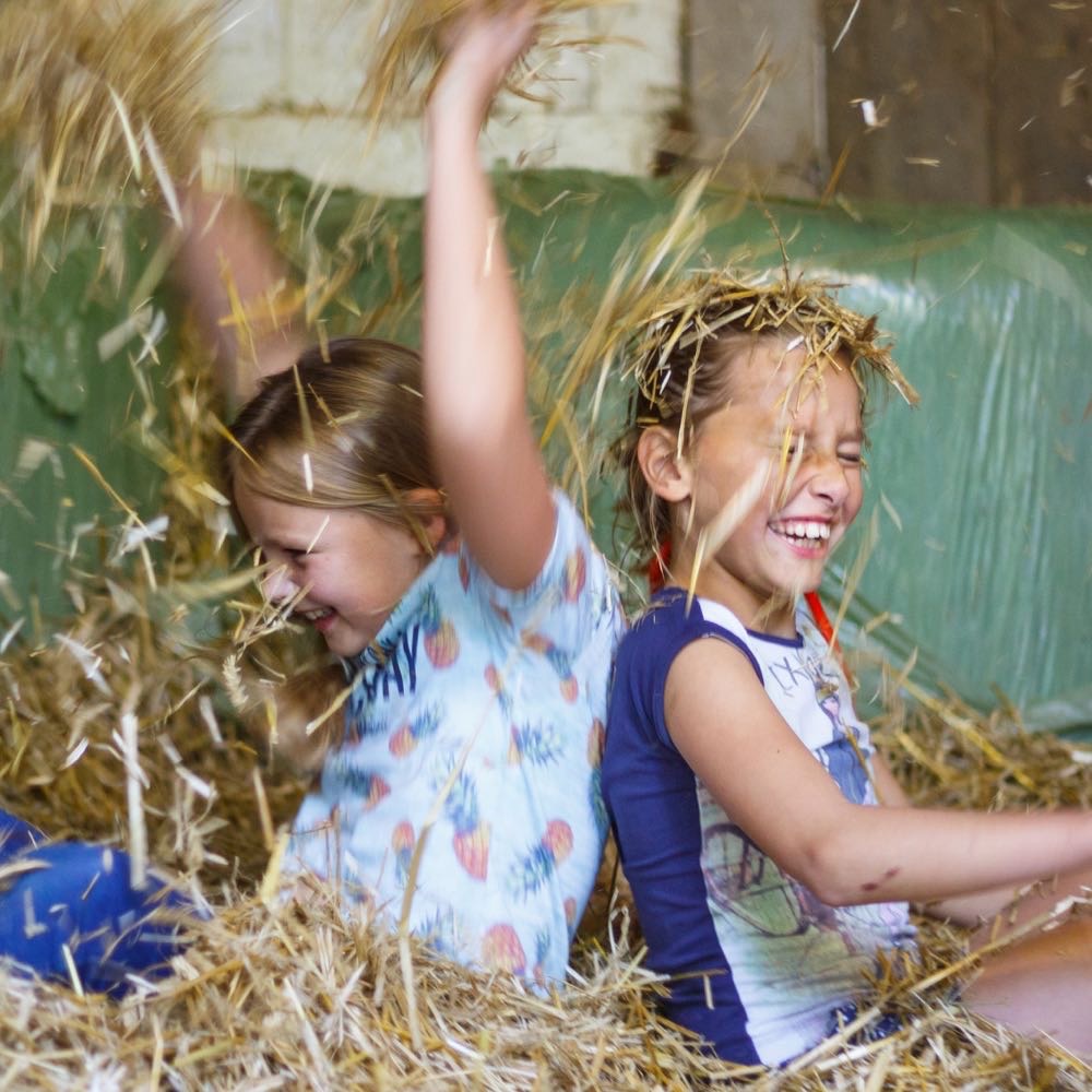 Spelen in het hooi tijdens een vakantie op de boerderij