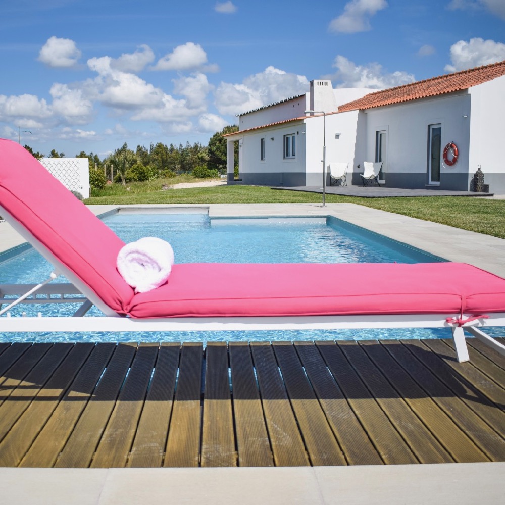 Een roze ligstoel aan de rand van het zwembad van Flamboyant B&B