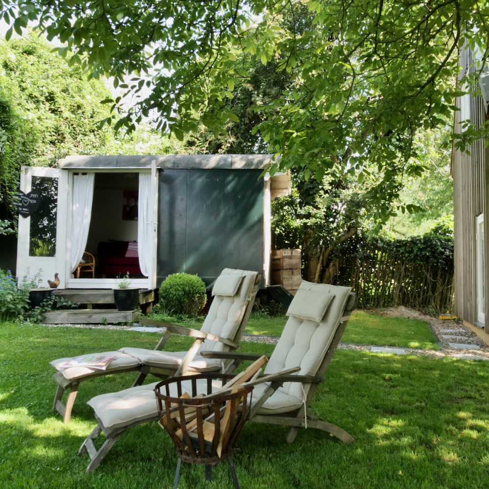 Ligstoelen voor pipowagen in een groene omgeving