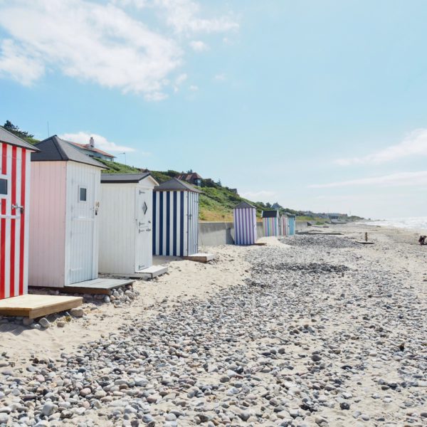 Gestreepte strandhuisjes op stenen strand