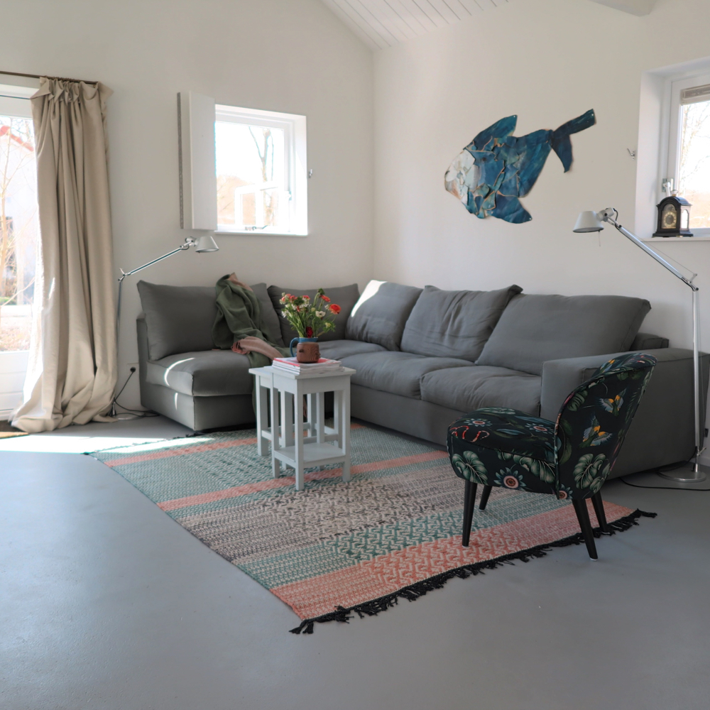 Zithoek met grijze bank en gekleurde fauteuil