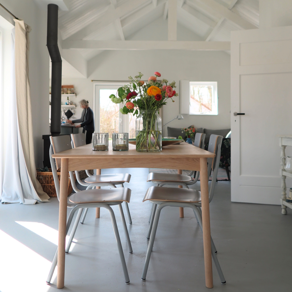 Doorkijkje vanaf de eettafel richting de houtkachel, keuken en zithoek