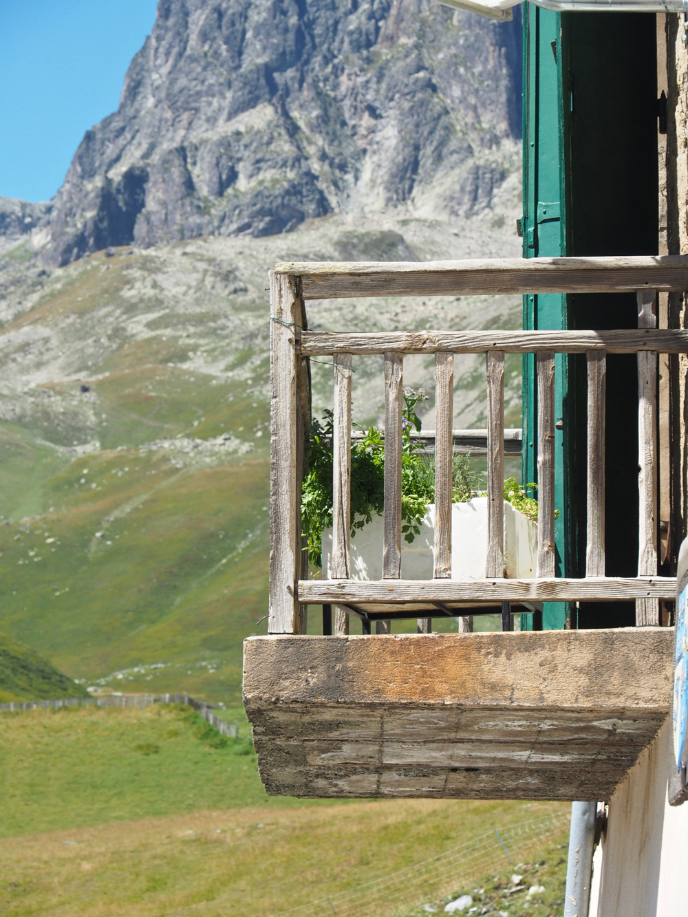 Hoog in de bergen een houten balkon met zicht op ruige toppen