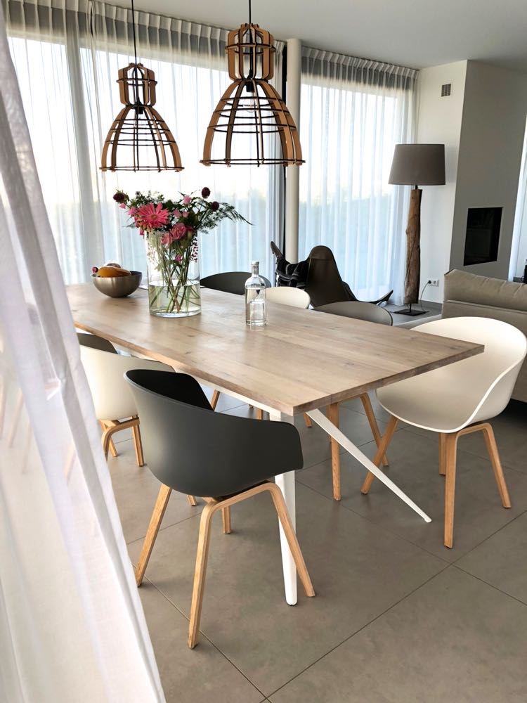 Een grote eettafel met 8 kuipstoelen in zwart en wit in de Z'AND villa