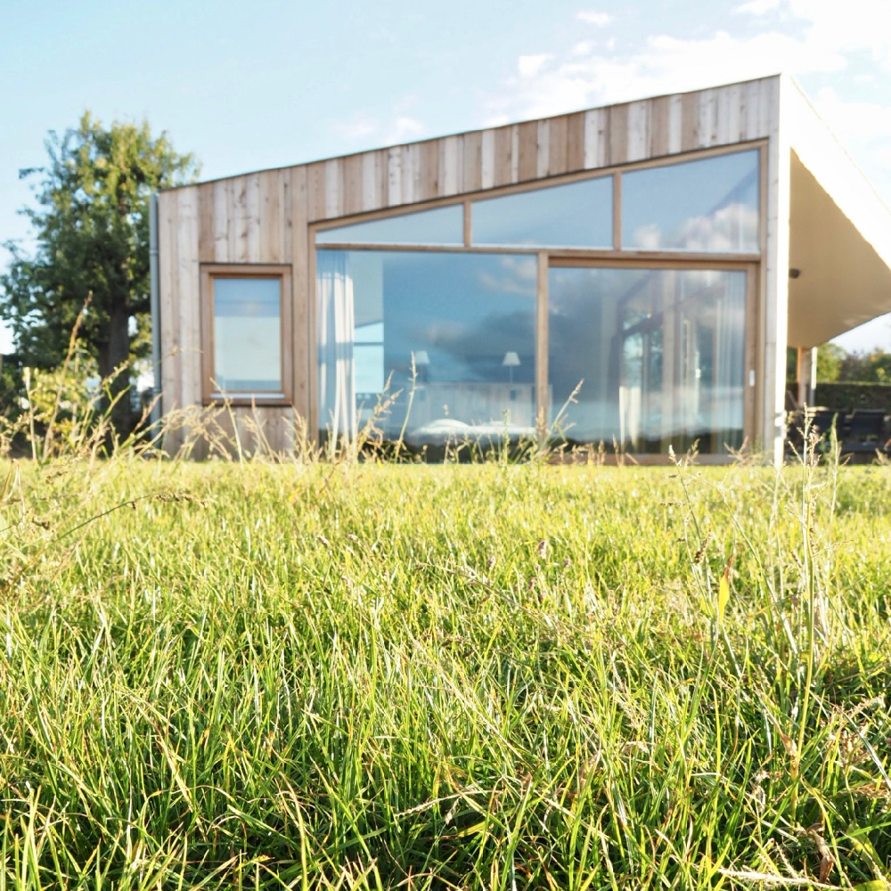 Een bed voor het raam, van buiten naar binnen gekeken.