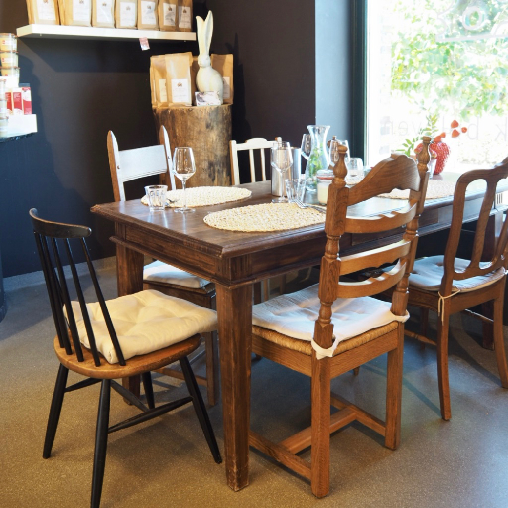 Een tafel voor het raam met verschillende stoelen