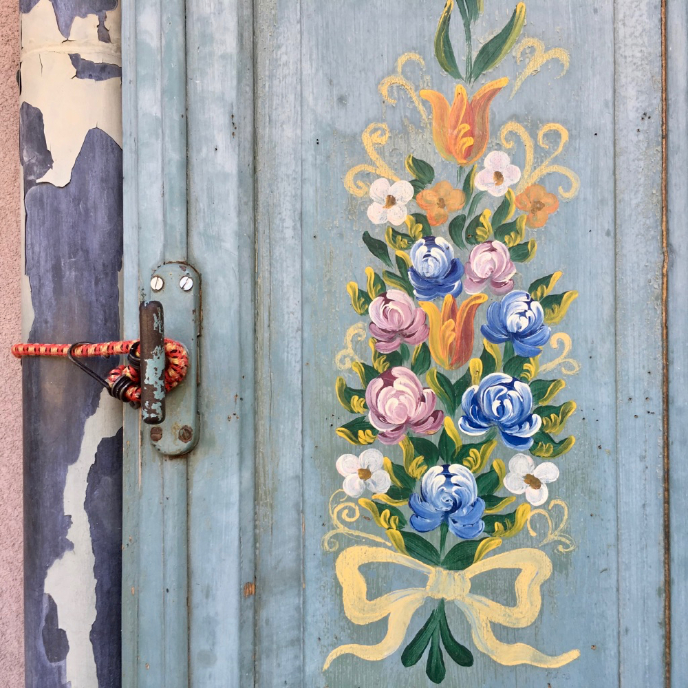 Geschilderde bloemen op een metalen deur