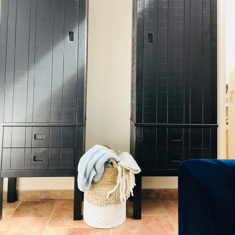 Twee antracietkleurige kasten met een rieten mand ervoor