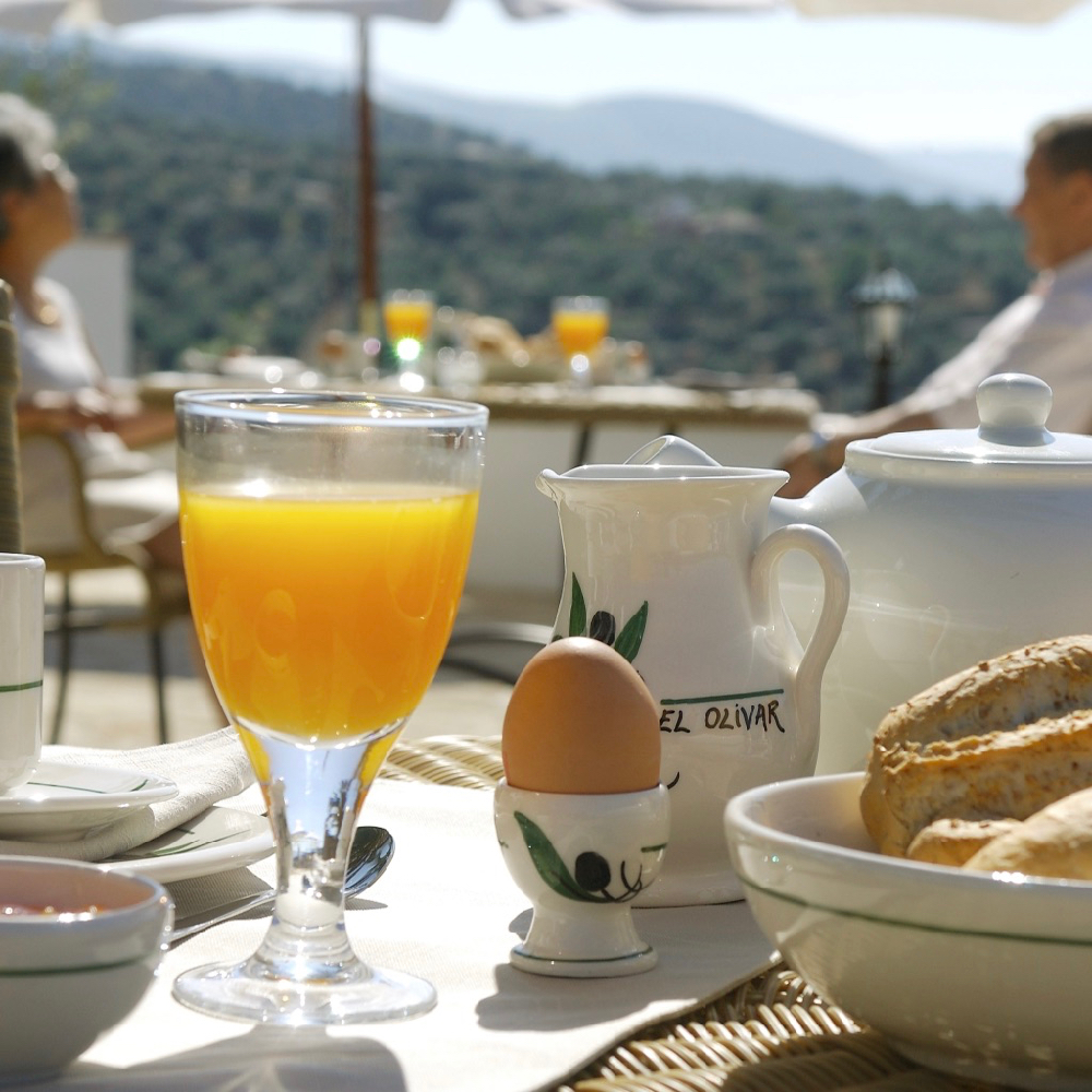 Ontbijt met jus d'orange, eitje en broodjes in de zon
