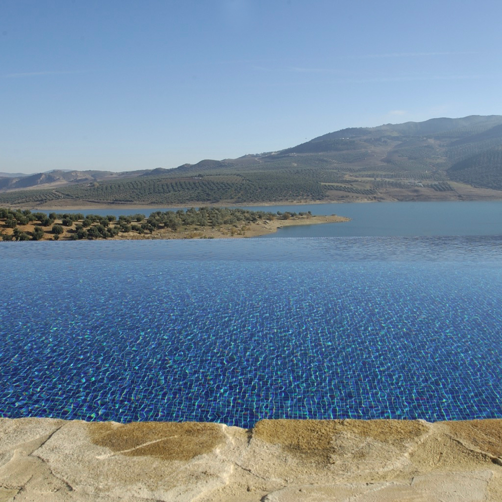 Infinity pool waarbij het lijkt alsof het water van het zwembad overgaat in het meer