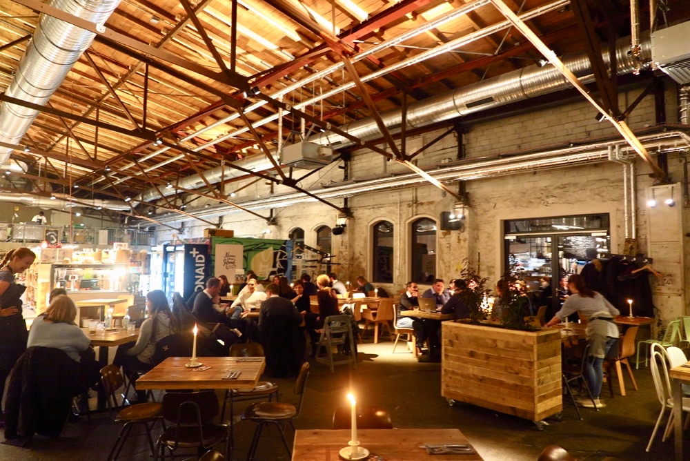 Stoer en industrieel interieur met hoog plafond met buizen en leidingen.