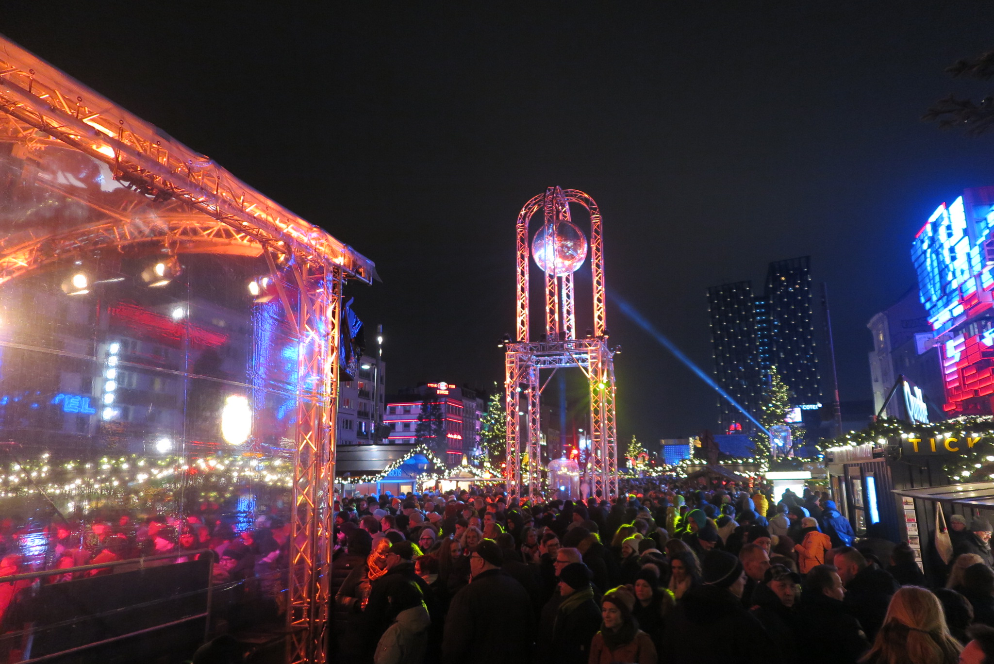 Een kerstmarkt met tientallen lampjes, in het donker 
